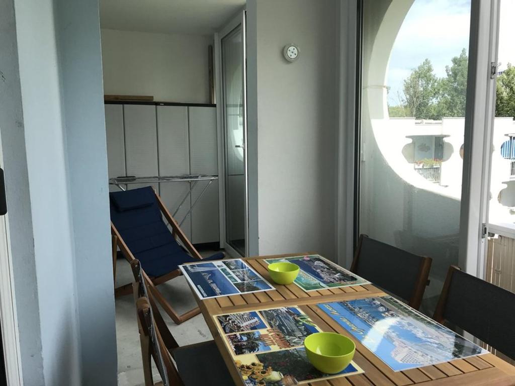 - une table à manger avec 2 bols verts dans l'établissement Appartement rénové 3 pièces, 6 couchages, proche plage et port, avec loggias et parking à La Grande-Motte - FR-1-790-24, à La Grande Motte
