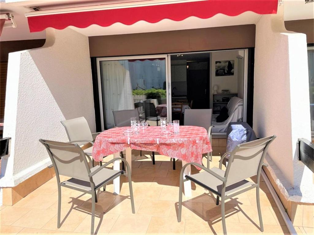 Une table à manger et des chaises sont disponibles sur la terrasse. dans l'établissement Studio Cabine à La Grande Motte - Plage Proche, Climatisé, Terrasse, Parking - FR-1-790-8, à La Grande Motte
