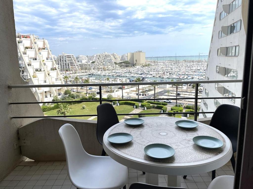 une table et des chaises sur un balcon avec vue sur une ville dans l'établissement Appartement 5 pers, Clim, Parking, 2 Ch - La Grande Motte - FR-1-790-9, à La Grande Motte