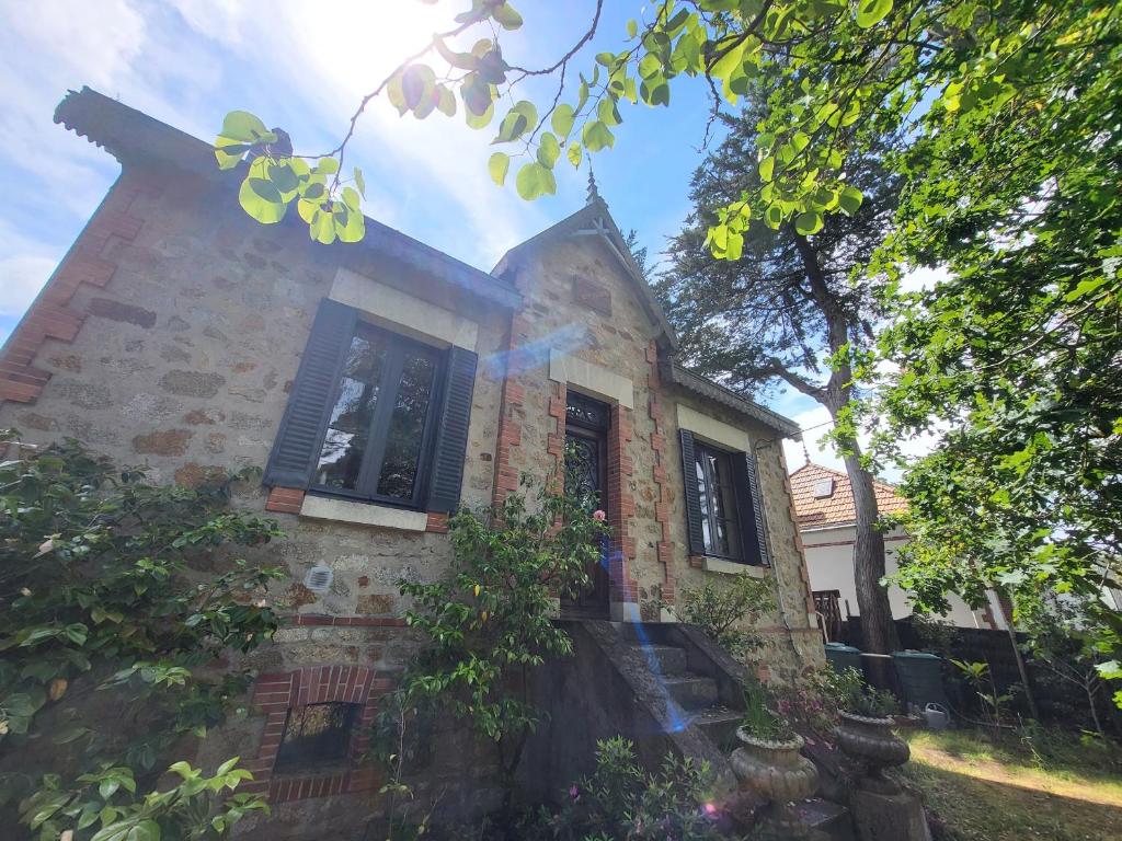 un vieux bâtiment en briques avec une fenêtre et des arbres dans l'établissement Échappez-vous à deux pas de la plage: Maison bretonne 6 pers. avec jardin et terrasse, St-Brevin - FR-1-364-172, à Saint-Brévin-les-Pins