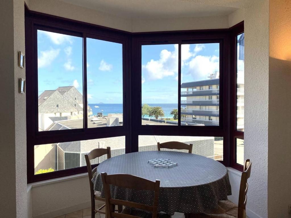 une salle à manger avec une table et une vue sur l'océan dans l'établissement Appartement à 200m de la plage avec 2 chambres et garage à Perros-Guirec - FR-1-368-422, à Perros-Guirec