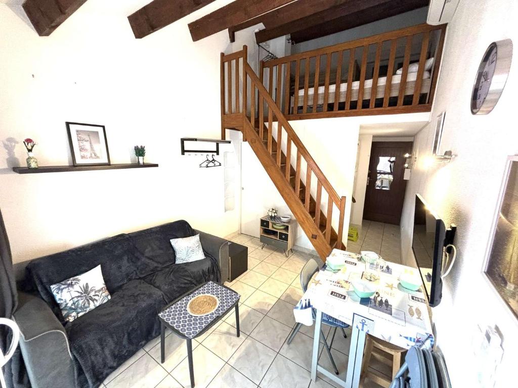 un salon avec un canapé et une table dans l'établissement Appartement Studio Climatisé avec Mezzanine et Terrasse à 400m de la Plage - 4 Couchages - FR-1-229C-97, à Port-la-Nouvelle