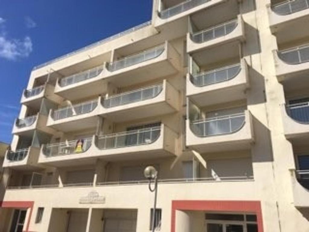 un grand bâtiment avec des balcons sur le côté dans l'établissement Studio cosy près de la plage des Présidents, tout équipé, loggia, quartier recherché, vélos gratuits - FR-1-325-131, à Les Sables-dʼOlonne