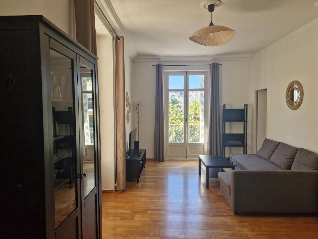een woonkamer met een bank en een raam bij Beautiful and bright 1st Floor Flat with large Terrace - Biarritz City Center in Biarritz