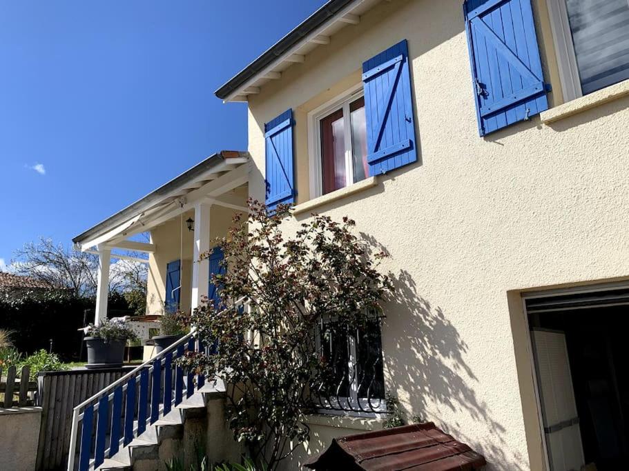 a house with blue windows and a plant on the steps at Maison 6 personnes Billom in Billom