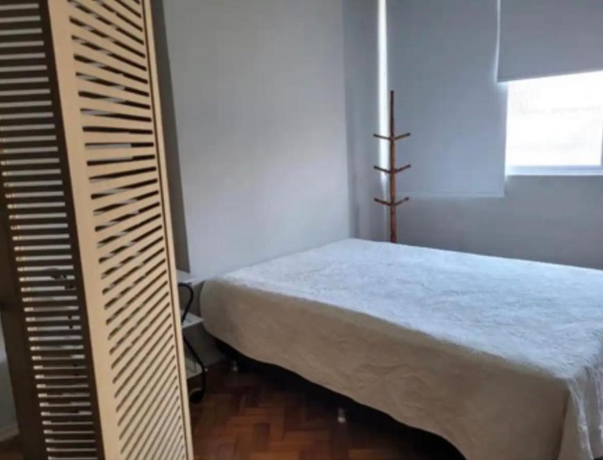 1 dormitorio con cama y ventana en Studio perto da praia, en Río de Janeiro