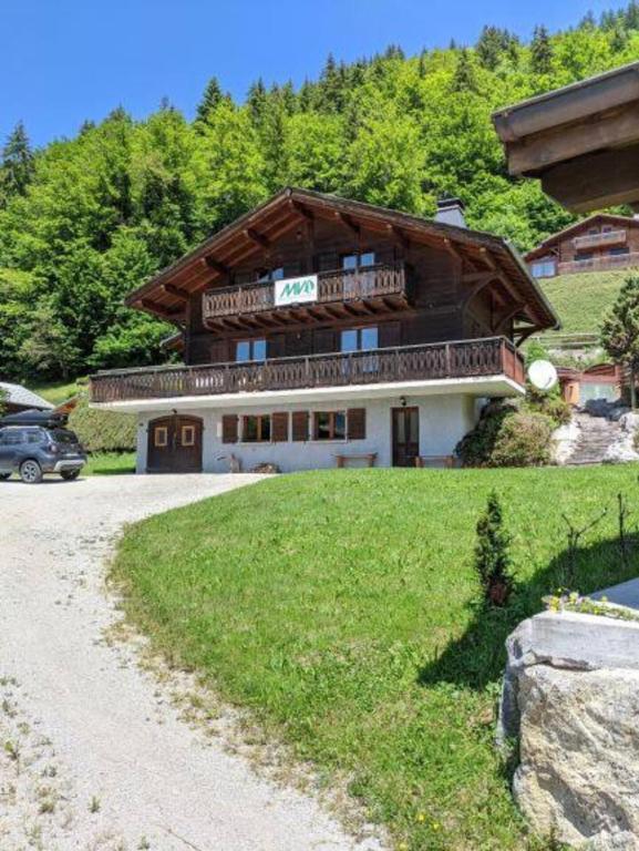 une maison sur une colline avec une voiture garée devant dans l'établissement Chalet Ruan Montriond - Mountain Voyages, à Montriond