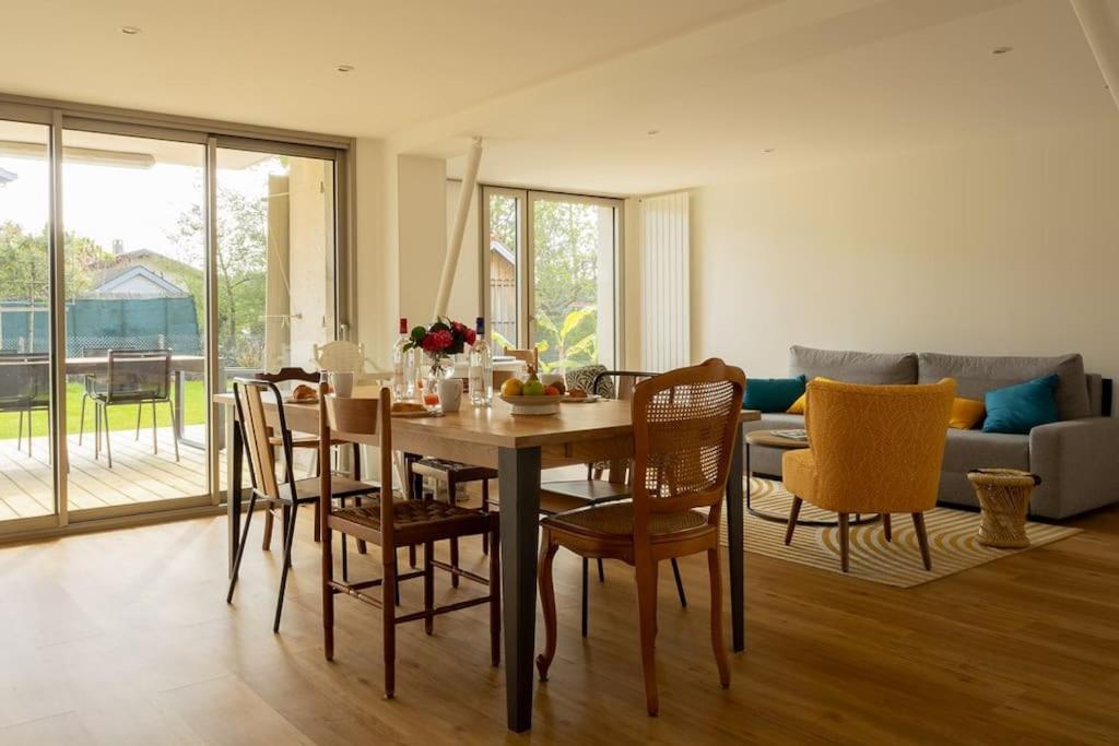 une salle à manger et un salon avec une table et des chaises dans l'établissement La Villa Jade, à La Teste-de-Buch