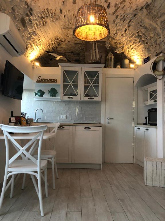 a kitchen with a table and chairs and a ceiling at KAMBUSA - Mono Fronte Mare in Santo Stefano al Mare