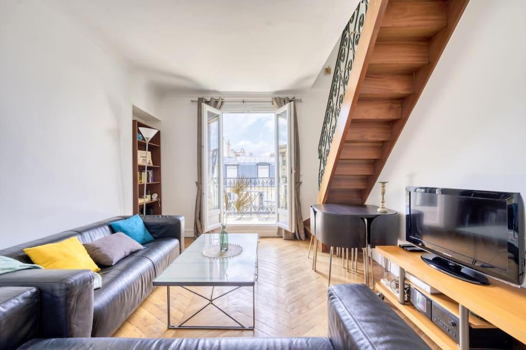 un salon avec un canapé et une télévision dans l'établissement 3-bedroom apart close to Roland Garros, à Paris