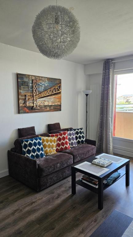 un salon avec un canapé et une table basse dans l'établissement Appartement proche de la plage de Cabourg, à Cabourg