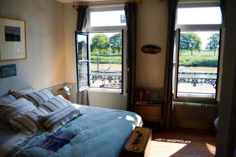 a bedroom with a bed and two windows at La Maison du Port in Saint-Valery-sur-Somme