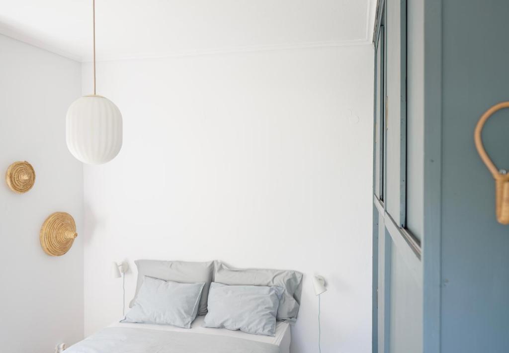 a white couch with pillows in a room with a window at A-ma-ru-to in Amarinthos