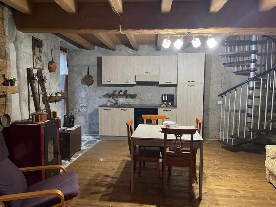 eine Küche und ein Esszimmer mit einem Tisch und Stühlen in der Unterkunft Stone House: fairytale flat with magic lake view in Bellano