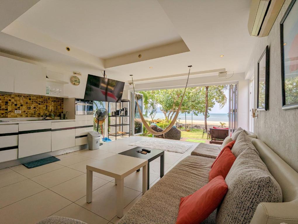a living room with a couch and a table at Beachfront Magic Villa - by KohChangVillas in Ko Chang
