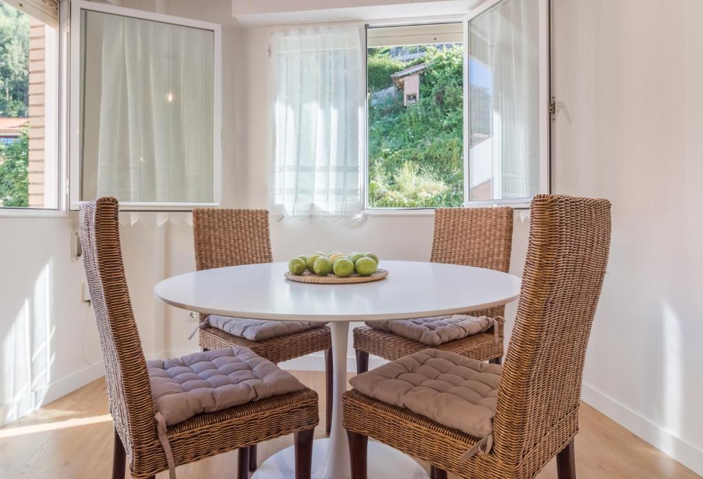 uma sala de jantar com uma mesa branca e cadeiras em Apart El Muelle Centro de Ribadesella VUT-3752-AS em Ribadesella