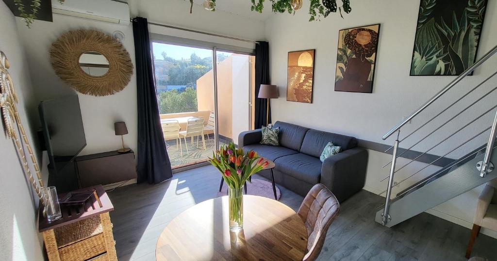 un salon avec un canapé et une table dans l'établissement Appartement en résidence avec piscine, à Bandol
