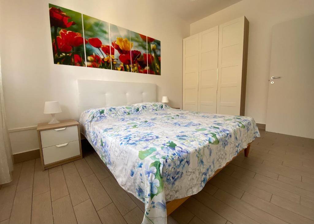 una camera da letto con un letto e un quadro sul muro di Donizetti Vacation Apartment a Porto Cesareo