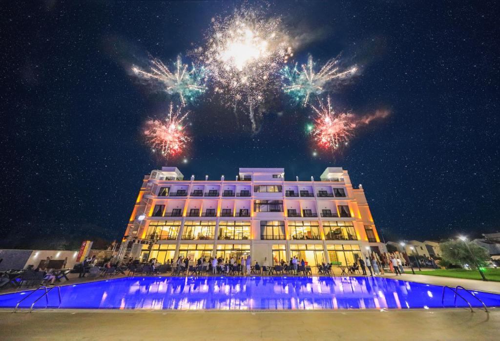 a building with fireworks in the sky behind it at Mc Palace Hotel Spa & Convention in Kyrenia