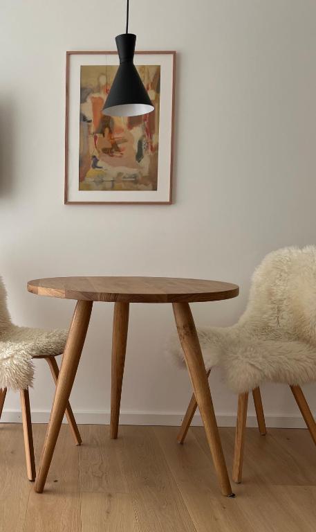 a table and two chairs in a room with a picture at Schickes 2-Zi-Apartment am Neckarufer im BUGA-Park in Heilbronn