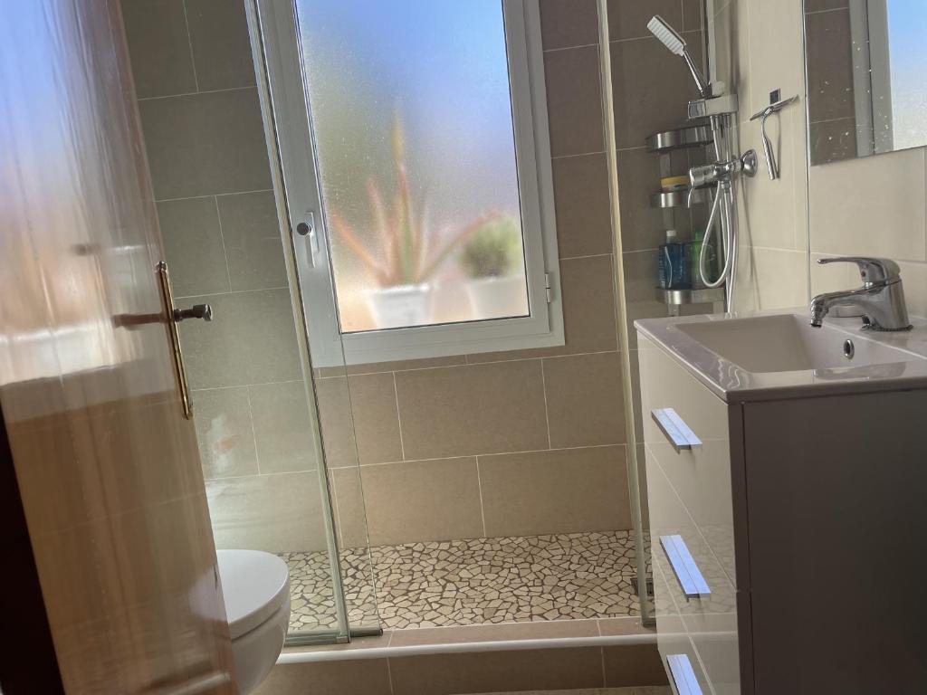 y baño con ducha, aseo y lavamanos. en Preciosa casa de playa, en S'Agaró