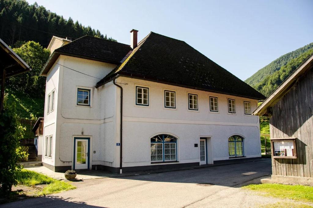 a white house with a black roof at Wohnung im Nationalpark Kalkalpen 3 in Reichraming