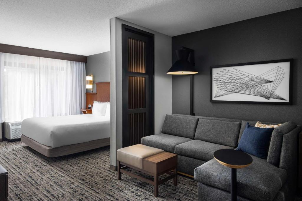pokój hotelowy z łóżkiem i kanapą w obiekcie Hyatt Place Atlanta Airport South w Atlancie