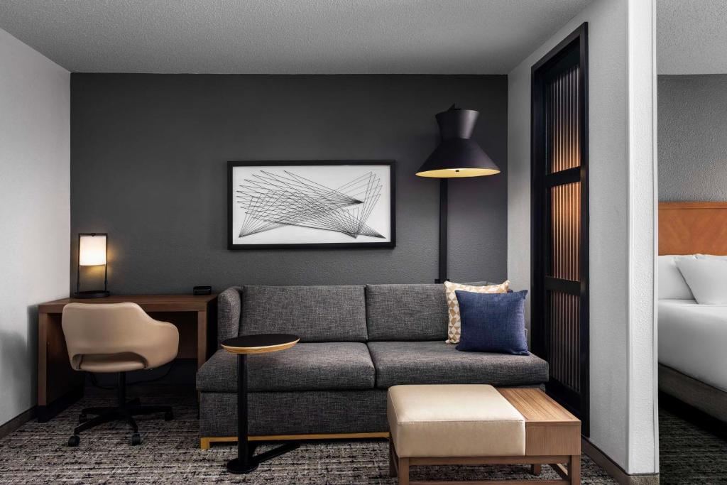 - un salon avec un canapé et un lit dans l'établissement Hyatt Place Dallas North, à Addison