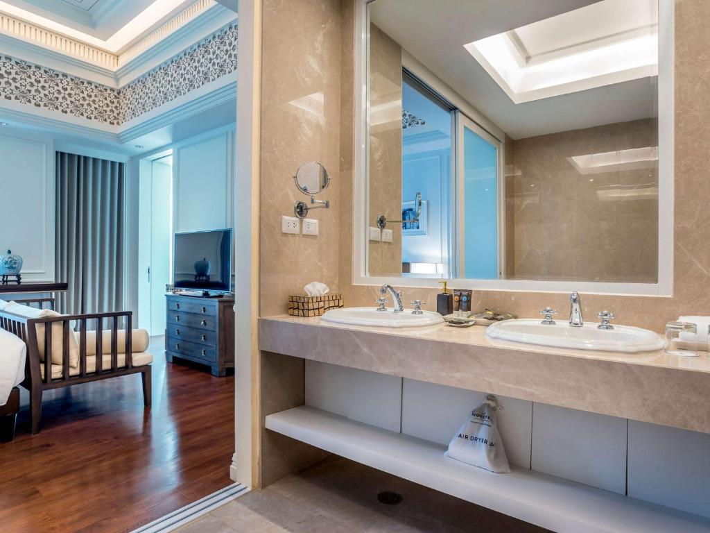 a bathroom with two sinks and a large mirror at Novotel Phuket City Phokeethra in Phuket Town