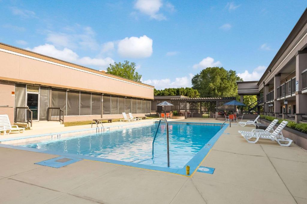 een zwembad met 2 stoelen en een gebouw bij Clarion Inn & Suites Russellville I-40 in Russellville