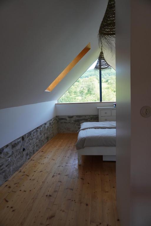 a bedroom with a bed and a large window at Stodola Počúvadlo in Počúvadlo