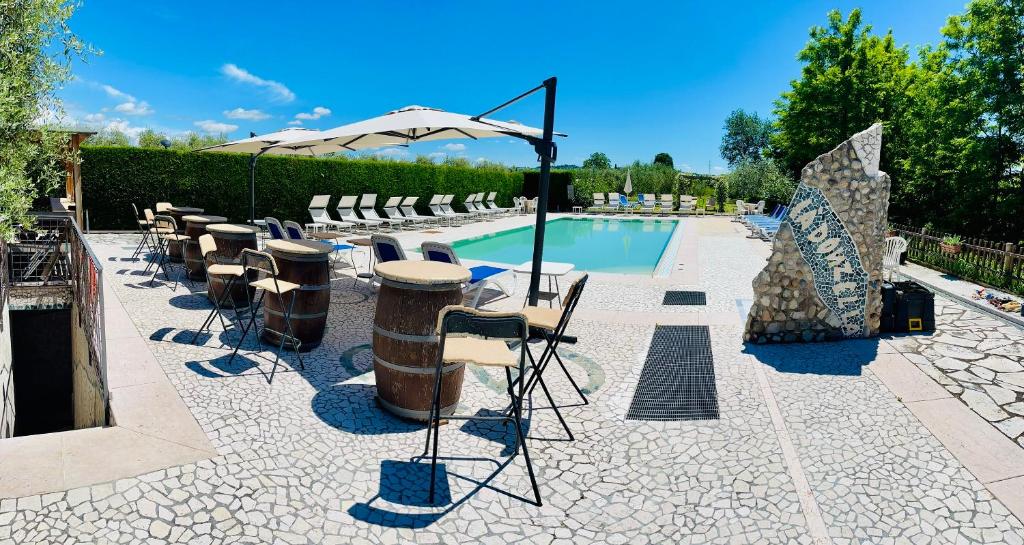 a pool with a bunch of chairs and an umbrella at Residenza Cà Donzella in Lazise