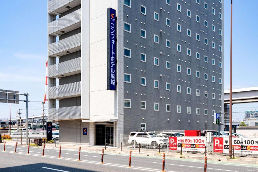 a building with a car parked in front of it at Comfort Hotel Kurosaki in Kitakyushu