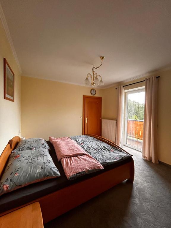 um quarto com uma cama grande e uma janela em Lederhof em Abtenau