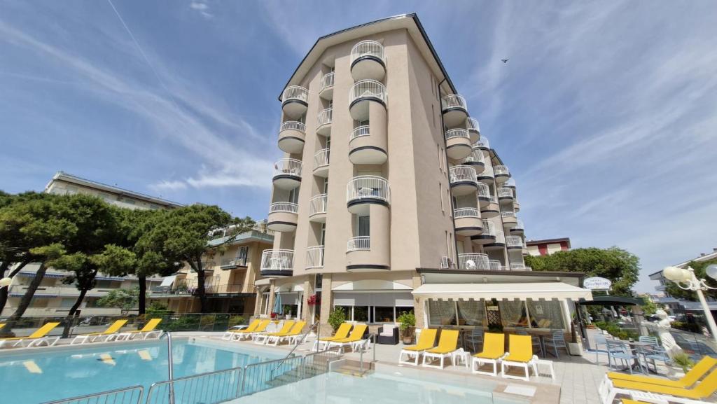 a hotel with a swimming pool in front of a building at Hotel Stockholm in Lido di Jesolo