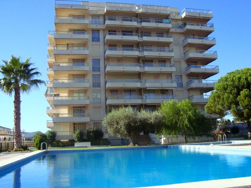 un hotel con piscina frente a un edificio en Alpen1 Mediterráneo, en Peñíscola