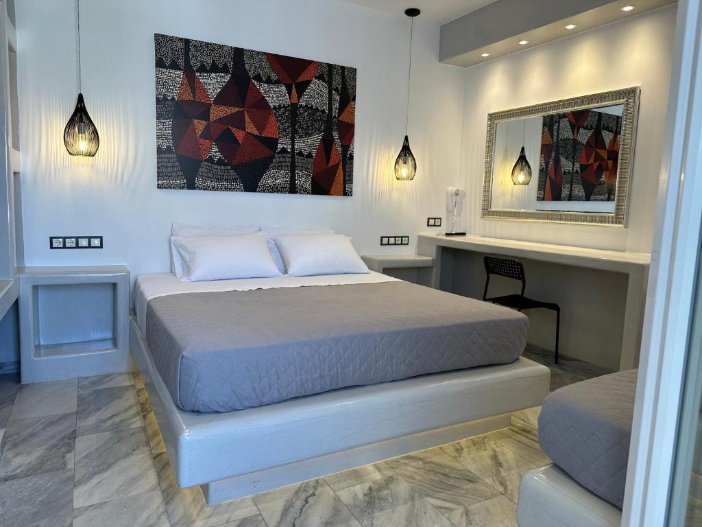 biała sypialnia z łóżkiem i biurkiem w obiekcie Aphrodite Hotel & Apartments w mieście Ios (Chora)