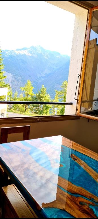 un lit dans une fenêtre avec vue sur une montagne dans l'établissement auron, à Saint-Étienne-de-Tinée