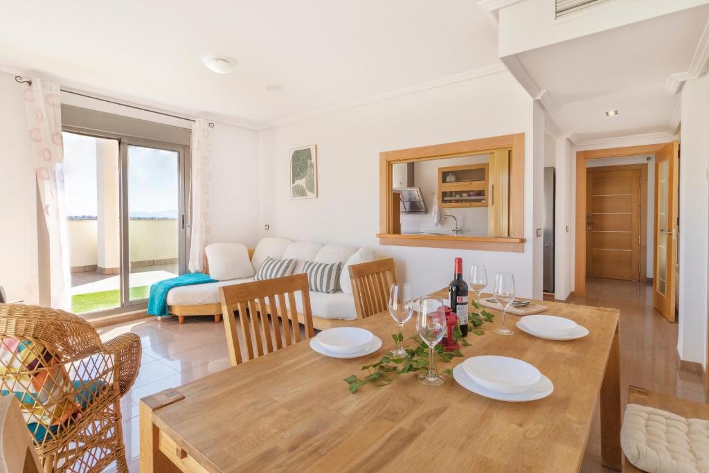 a dining room and living room with a table and chairs at Penthouse in the Sun in El Alquián