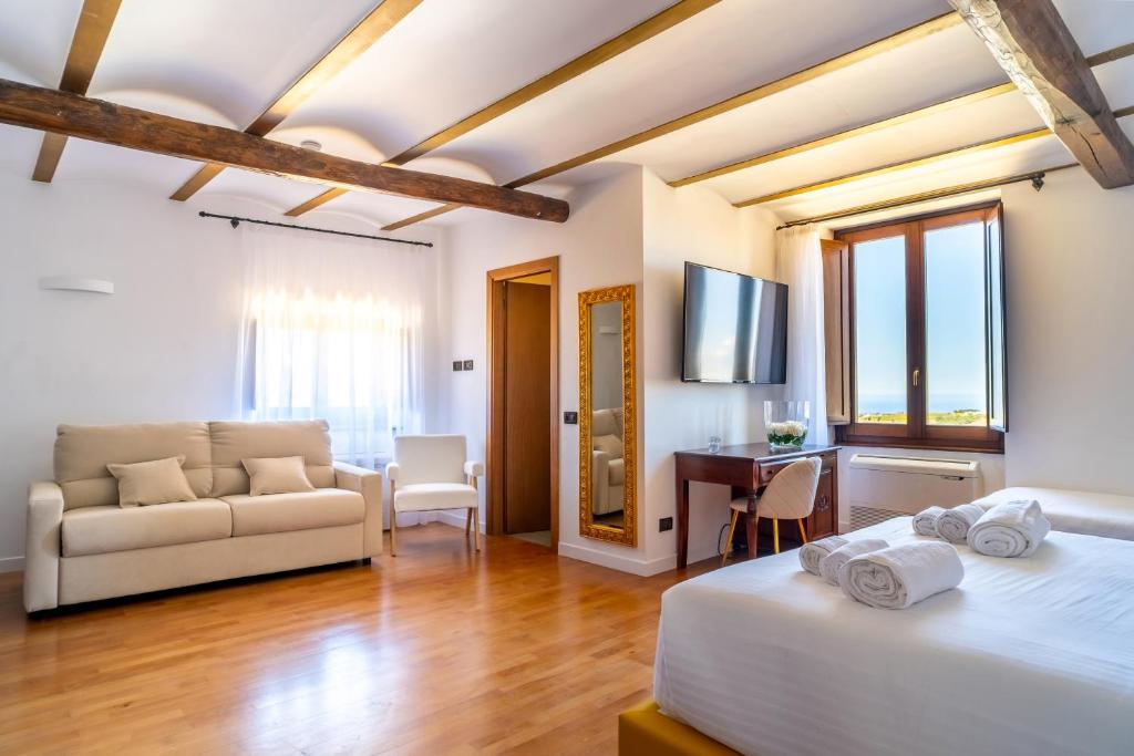 1 dormitorio con sofá y escritorio en una habitación en Villa Vittoria Hotel, en Alcamo