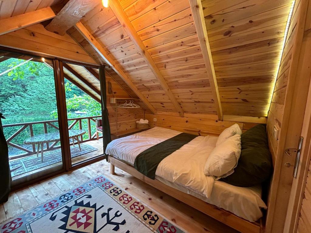 una camera con un letto in una baita di tronchi di Nehir Bungalows a Dikkaya