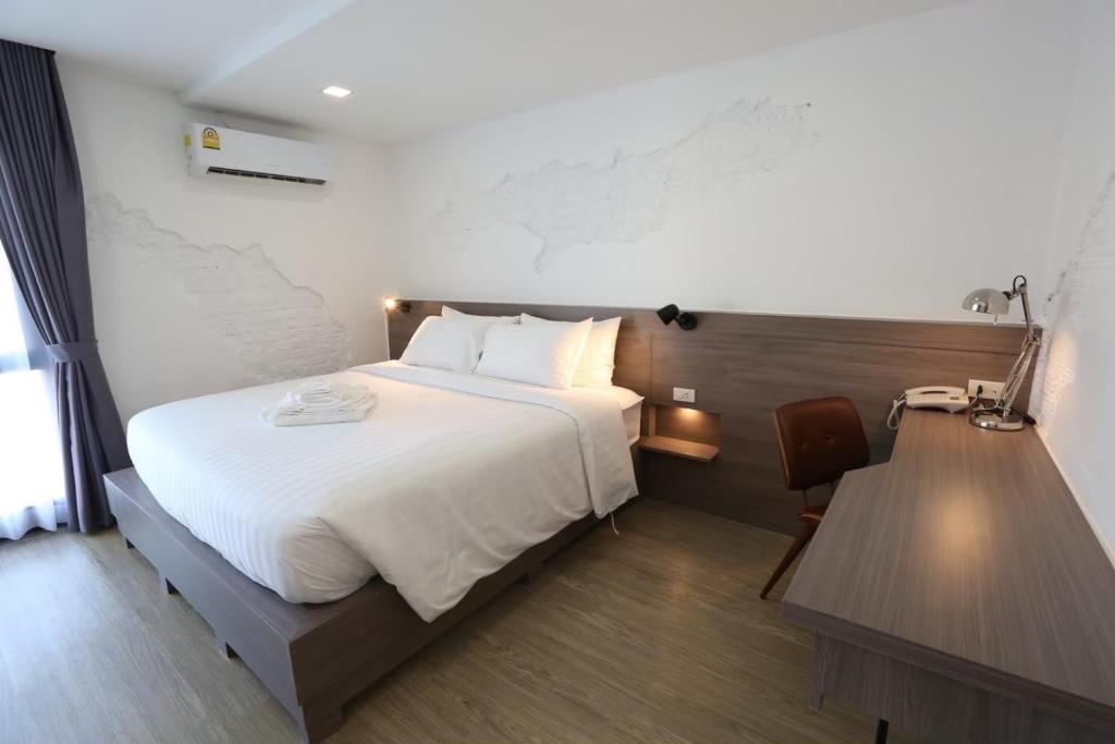 バンコクにあるU42 Hotel Bangkokのベッドとデスクが備わるホテルルームです。