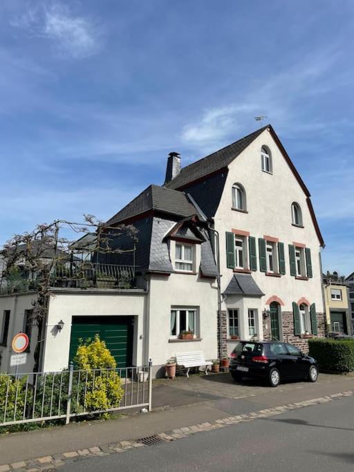 a white house with a car parked in front of it at Ferienwohnung Moselsteig in Reil