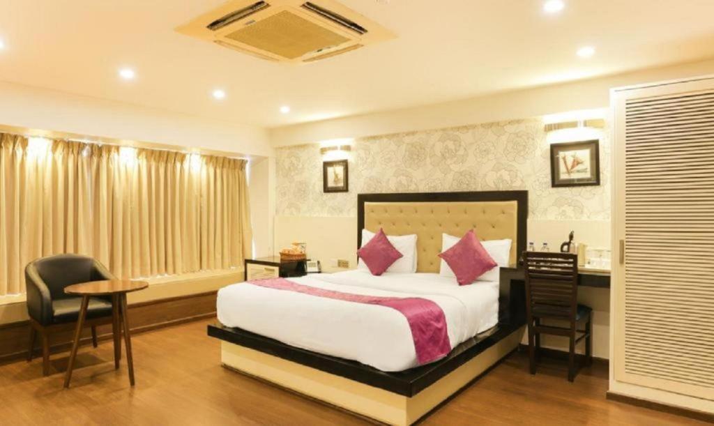 een hotelkamer met een bed, een bureau en stoelen bij Airport Hotel Classic Park in New Delhi