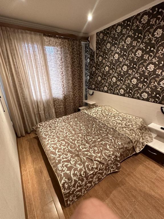 a bedroom with a bed with a black and white blanket at Appartment in Tsakhkadzor Mori Plaza in Tsaghkadzor