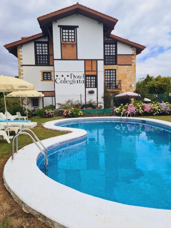 una casa con piscina frente a un edificio en Hotel Colegiata, en Santillana del Mar