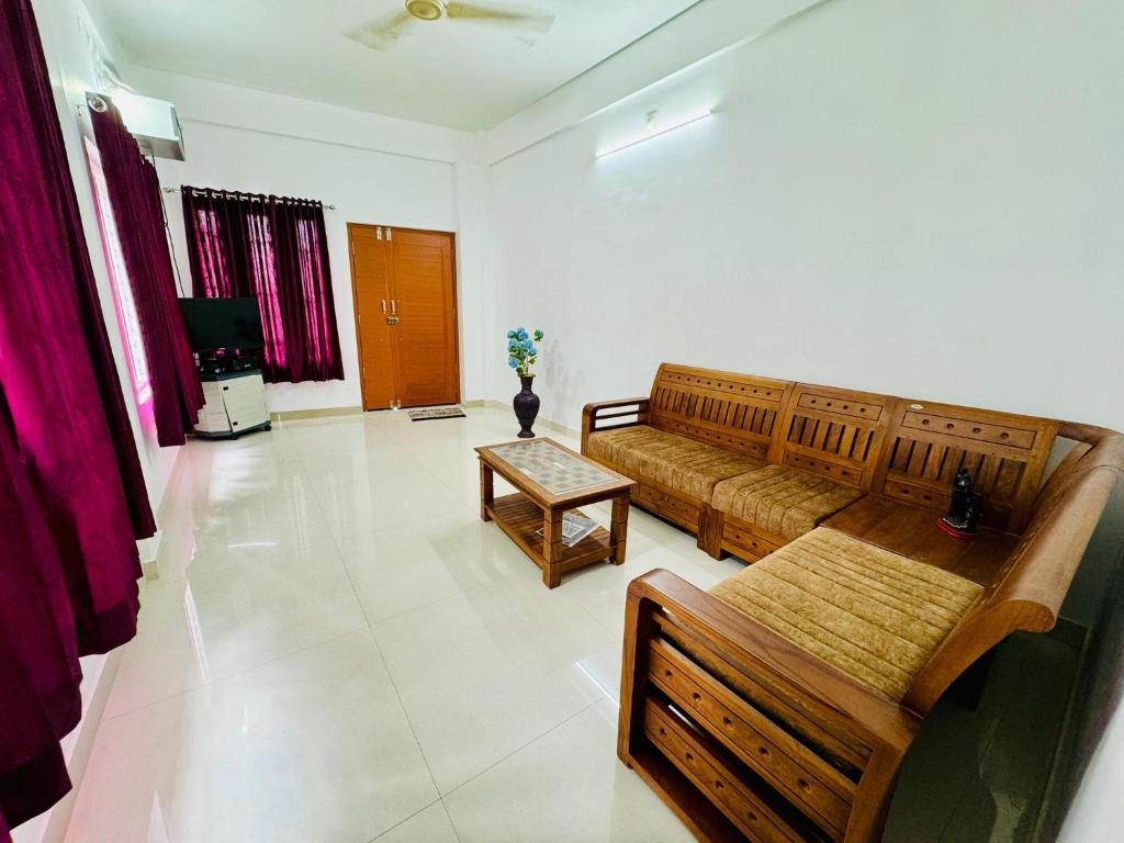 Spacious 2BHK Near Airport في كوتشي: غرفة معيشة مع أريكة وطاولة