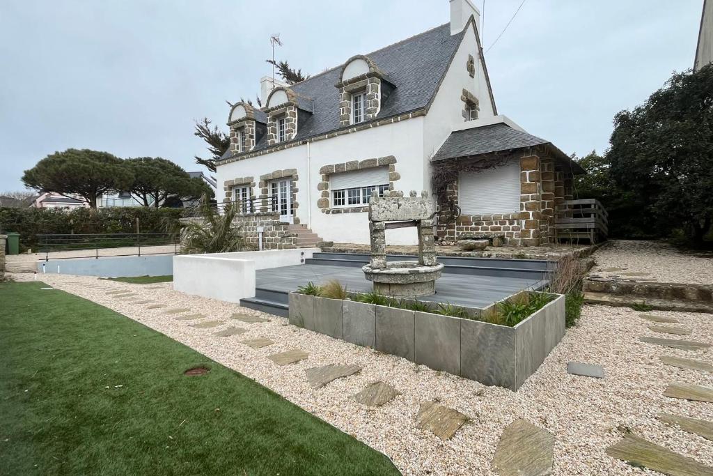 une maison avec une croix en face de celle-ci dans l'établissement Grande maison vue mer la grande plage a pied, à Quiberon