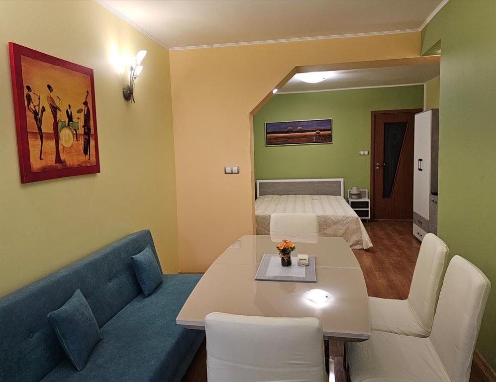 a room with a couch and a bed and a table at Cozy Place - в центъра, само на 5 минути пеша от плажа in Burgas