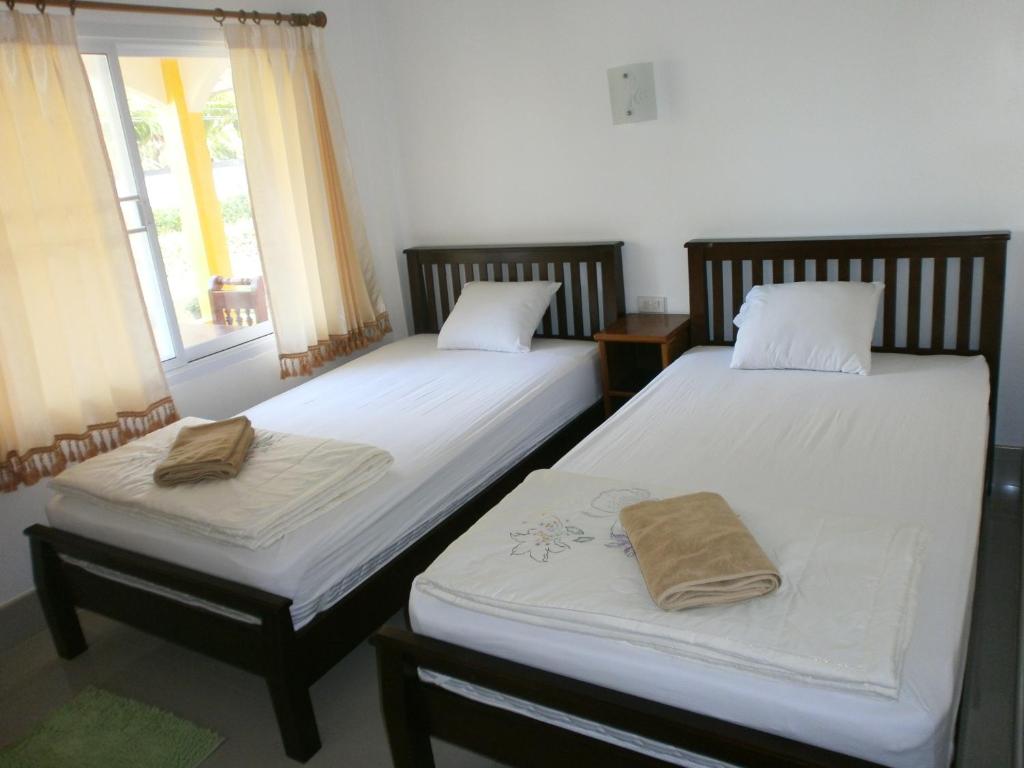 deux lits jumeaux dans une chambre avec fenêtre dans l'établissement Lanta Together, à Ko Lanta